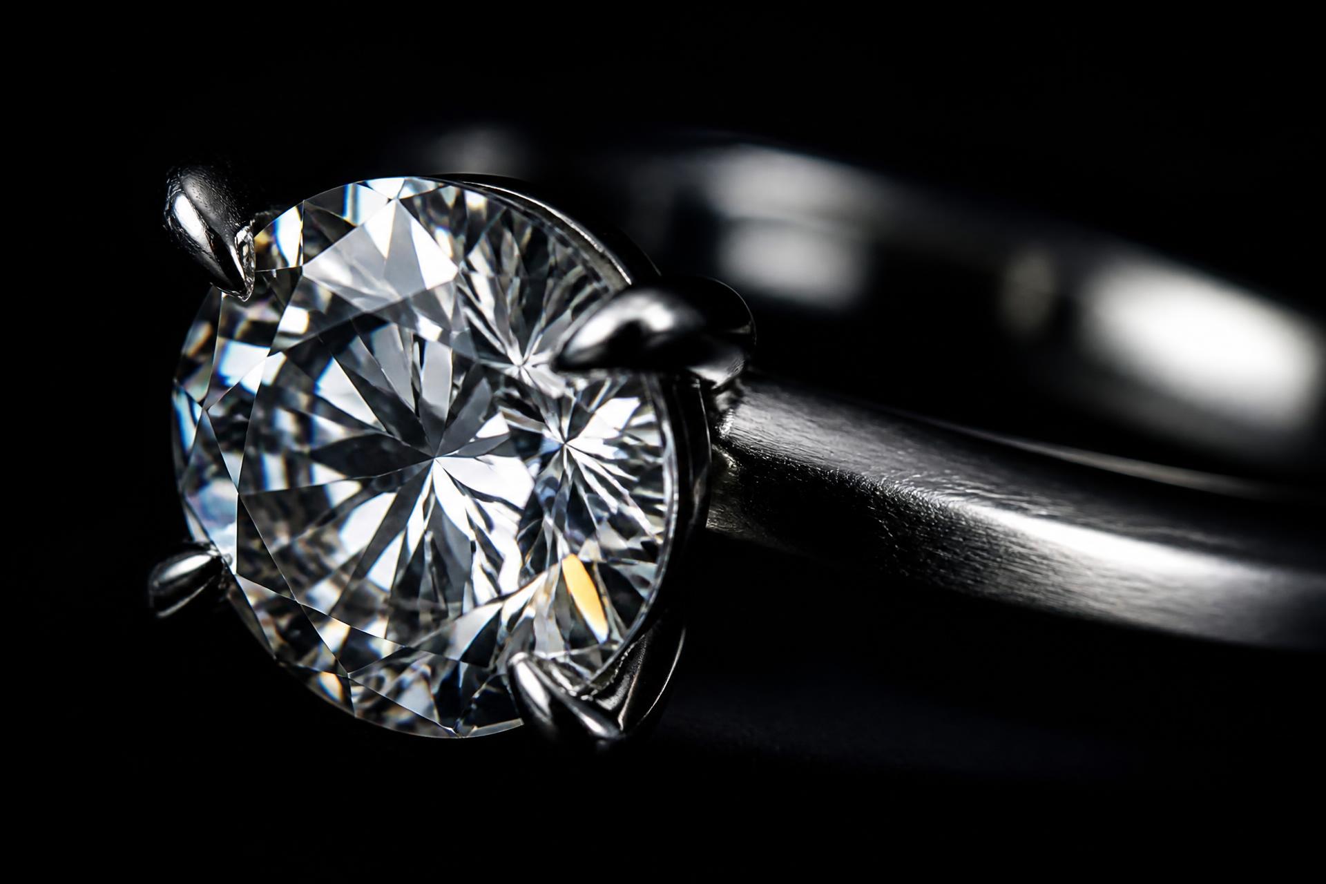 Macro photograph of a solitaire diamond engagement ring under dramatic light